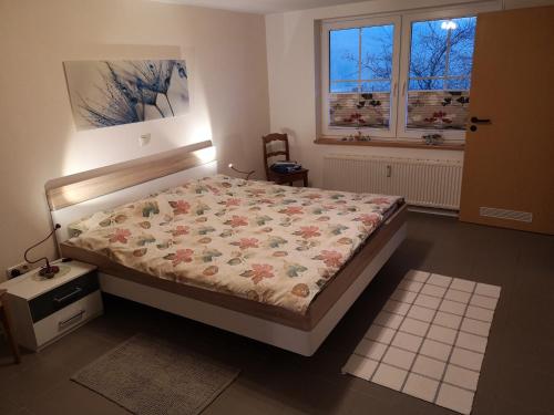 a bedroom with a bed with a floral comforter at Ferienwohnung Schmahl in Schleiden