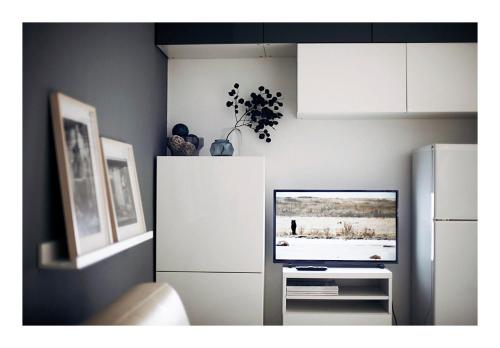 een woonkamer met een televisie en een koelkast bij Taking a WALK in the beating HEART of NAVIGLI in Milaan