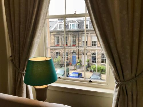 a green lamp sitting in front of a window at Escape To Edinburgh @ Broughton Place in Edinburgh