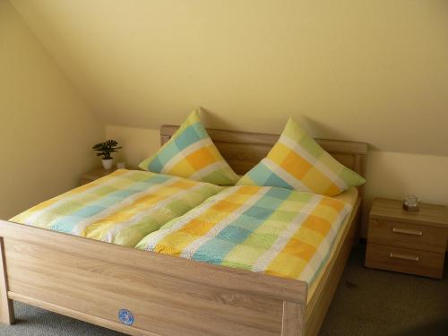 a bedroom with a wooden bed with pillows on it at Hausnordlicht FEWO 3 in Dornum