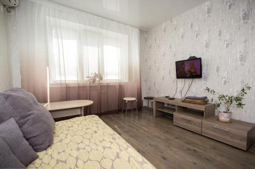ドニプロにあるApartment on Gagarina Avenueのベッド、テレビ、テーブルが備わる客室です。