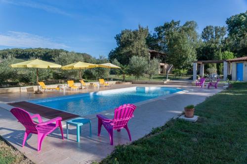 - une piscine avec des chaises roses, une table et des chaises dans l'établissement Domaine de Sonnard, à Castéra-Verduzan