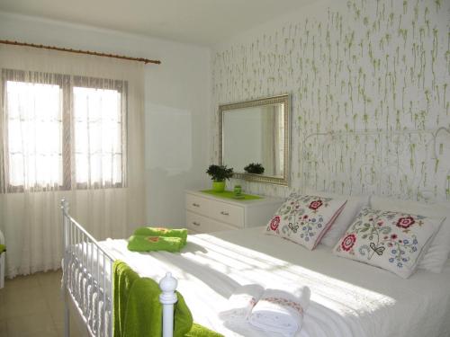 1 dormitorio con cama blanca y espejo en Casa Montaña de Tahiche, en Tahiche