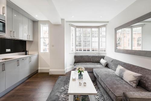 ein Wohnzimmer mit einem Sofa und einem Tisch in der Unterkunft Beautiful Chelsea Apartment in Fashion District in London