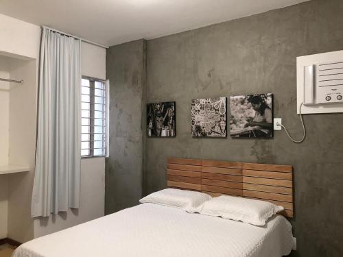 a bedroom with a white bed and two pictures on the wall at 2 min do mar Ponta Verde in Maceió