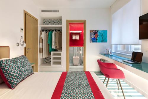 1 dormitorio con cama, escritorio y silla roja en Casa Dominova de Luxe en Sorrento
