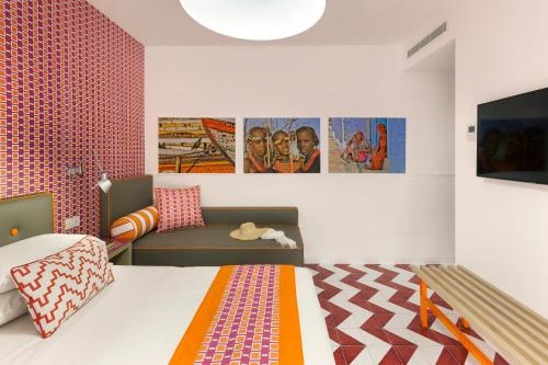 a bedroom with a bed and a couch and posters at Casa Dominova de Luxe in Sorrento
