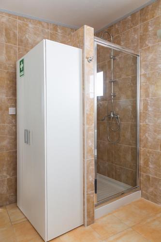 a shower with a glass door in a bathroom at Tales Of Us Terrace in Aveiro
