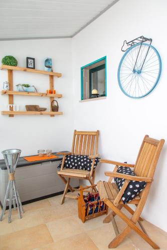 two chairs and a desk with a bike on the wall at Tales Of Us Terrace in Aveiro