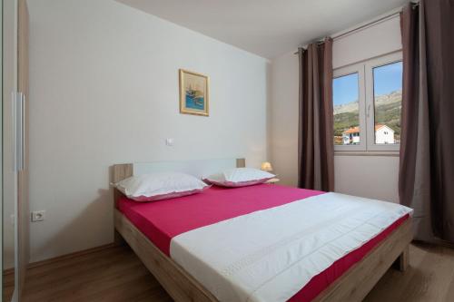 een slaapkamer met een groot bed met een raam bij Luxury apartment Nora in Podstrana