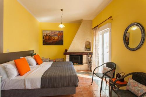 sypialnia z łóżkiem z pomarańczowymi poduszkami i kominkiem w obiekcie Evelia Apartment w mieście Galatás