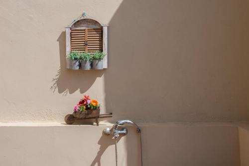 een raam met twee potplanten op een muur bij Evelia Apartment in Galatás