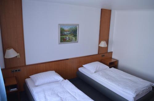 ein Schlafzimmer mit 2 Betten und einem Bild an der Wand in der Unterkunft Hotel Zur Post in Neubruchhausen