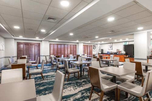 a dining room with tables and chairs at Wingate by Wyndham Charlotte Concord Mills/Speedway in Concord