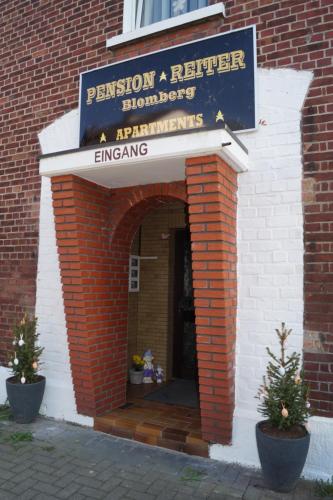 an entrance to a brick building with a sign at Pension Reiter in Blomberg