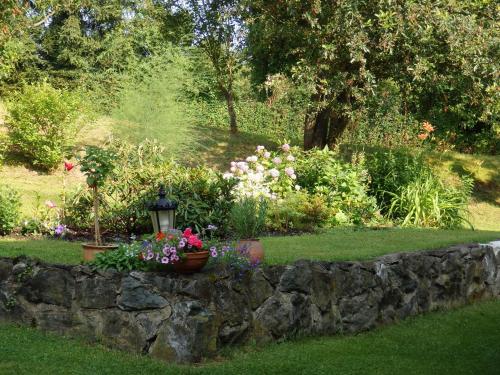 a stone retaining wall with flowers in a garden at Villa Blanka in Horní Podkozí