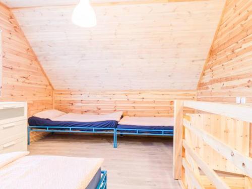 a room with two beds in a wooden cabin at Domki Anchor in Lubiatowo