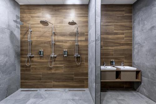 a bathroom with two sinks and two showers at Lake Hill Karkonosze Resort & Spa in Sosnówka