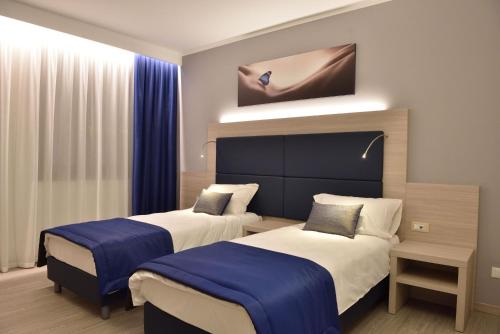 two beds in a room with blue and white at Residence Al Barcon in Sarcedo