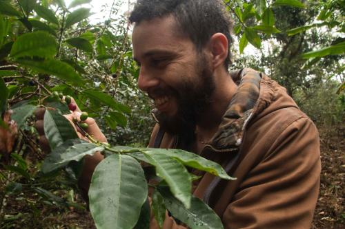 a man is smiling while standing next to a tree at Eco Hotel El Columpio in Salento