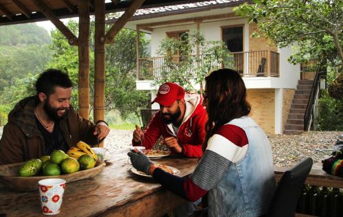 a group of people sitting around a wooden table at Eco Hotel El Columpio in Salento