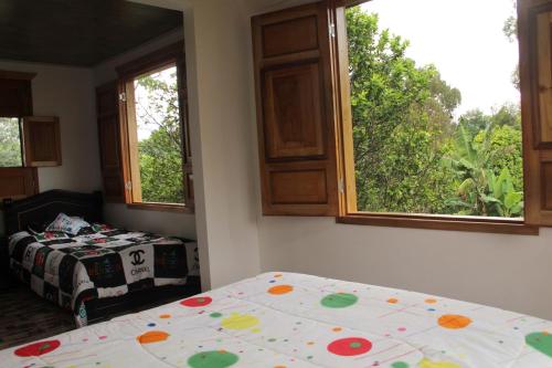 a bedroom with a bed and two windows and a bed sidx sidx sidx at Eco Hotel El Columpio in Salento
