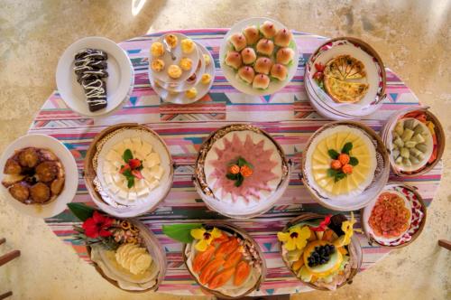 stół z wieloma talerzami jedzenia w obiekcie Pousada Jardim Das Margaridas w mieście Trancoso