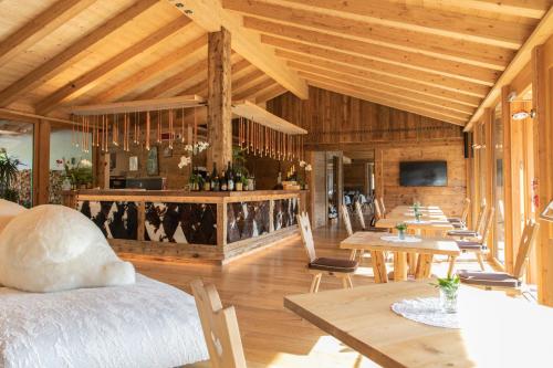 a room with wooden ceilings and tables and chairs at Dolomiti Lodge Alverà in Cortina dʼAmpezzo