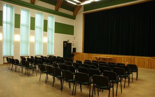 a room with a bunch of chairs in front of a screen at Dom Litewski in Sejny