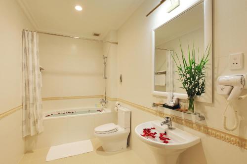 a bathroom with a toilet and a sink and a tub at Hotel Continental Saigon in Ho Chi Minh City