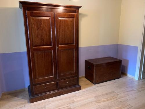 a large wooden cabinet and a stool in a room at Agriturismo Campolungo in Cutigliano