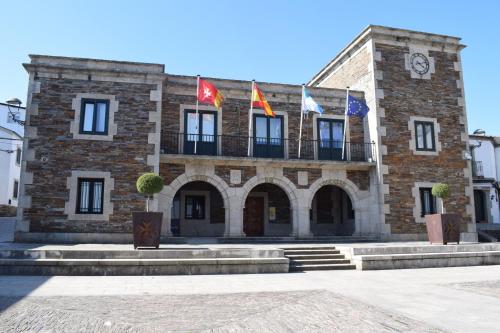 a large brick building with flags in front of it at La Casa de Manuel in Portomarin