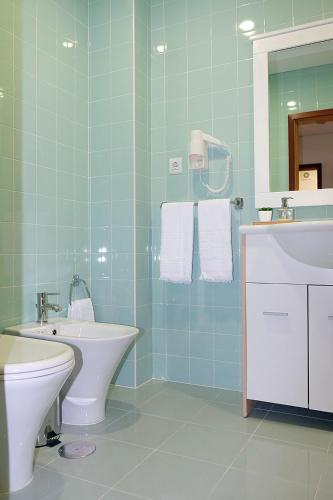 a bathroom with a sink and a toilet and a mirror at Marisol Ocean View in Praia da Barra
