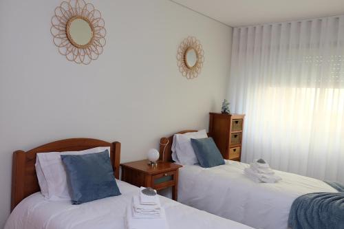 a bedroom with two beds and a mirror on the wall at Marisol Ocean View in Praia da Barra