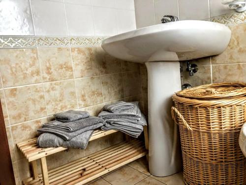 a bathroom with a sink and towels on a shelf at Casa Rimasco in Rimasco