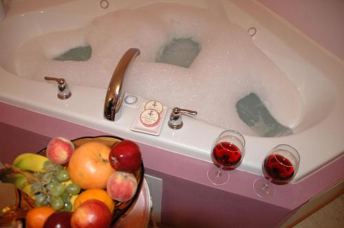 a bath tub filled with water next to a bowl of fruit at Inn Port D'Vino in Dayton