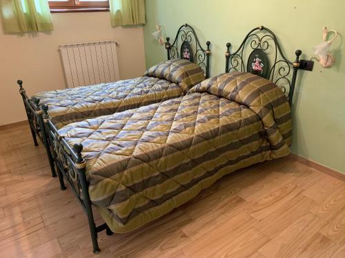 2 Betten in einem Schlafzimmer mit Bettrahmen in der Unterkunft Agriturismo Campolungo in Cutigliano