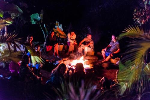 a group of people sitting around a fire at night at Ceiba by Masaya Collection in San Agustín