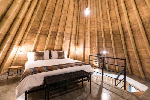 a bedroom with a bed in a bamboo wall at Ceiba by Masaya Collection in San Agustín