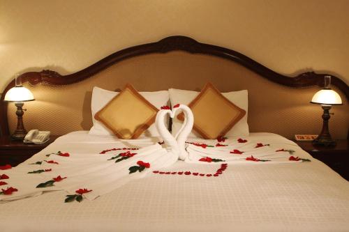 a bed with a swan made out of flowers at Hotel Continental Saigon in Ho Chi Minh City