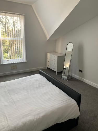 a bedroom with a bed and a mirror and a dresser at No 9 - LARGE 1 BED NEAR SEFTON PARK AND LARK LANE in Liverpool