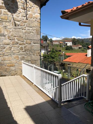a balcony with a white railing and a stone wall at Casinha Minhota in Eirado
