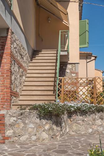 a building with stairs and a green door on it at MADI' casa vacanze in Laiatico