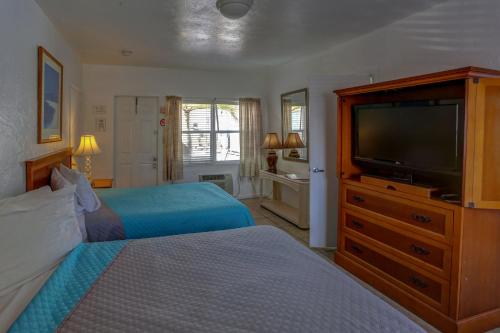 1 dormitorio con 2 camas y TV de pantalla plana en Richard's Motel Courtyard, en Hollywood
