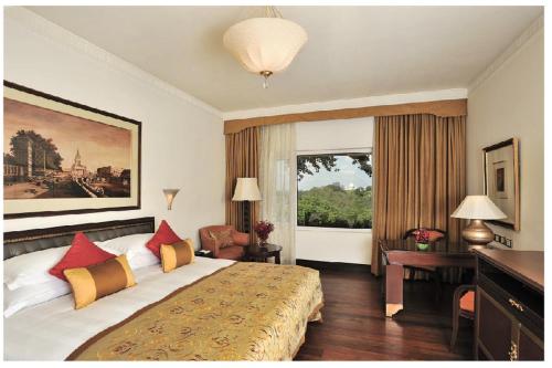 Säng eller sängar i ett rum på Taj Bengal