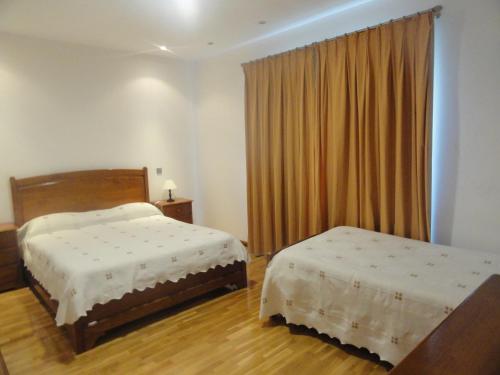 1 dormitorio con 2 camas y ventana en Hotel Cabeço do Forte, en Miranda do Douro