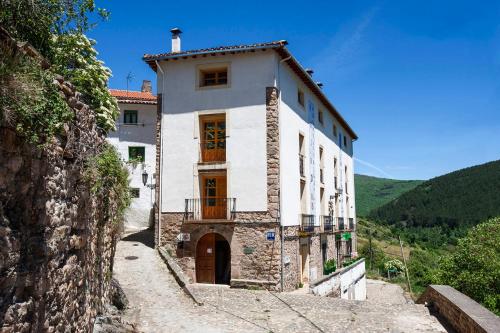 an old building on a hill with a stone wall at Posada Hoyos de Iregua in Villoslada de Cameros