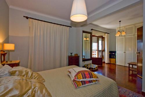 a bedroom with a bed and a room with a window at Traditional Villa In S Pedro , ESTORIL in Alapraia