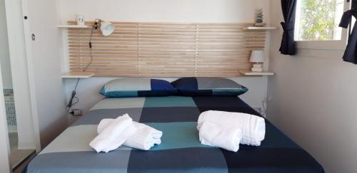 a bedroom with a bed with towels on it at Bungalow Minonthebeach in Gaeta