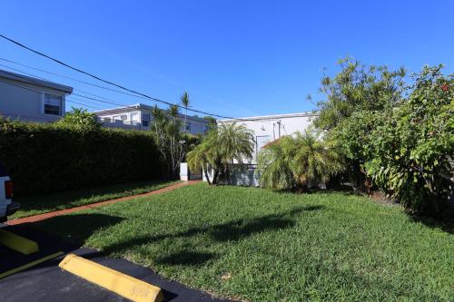 a yard with grass and palm trees and a building at Richard's Hotel in Hollywood